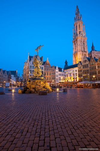 The Brabo statue and cathedral of Our Lady at twilight in the Grote Markt square old city center in Antwerp, Belgium